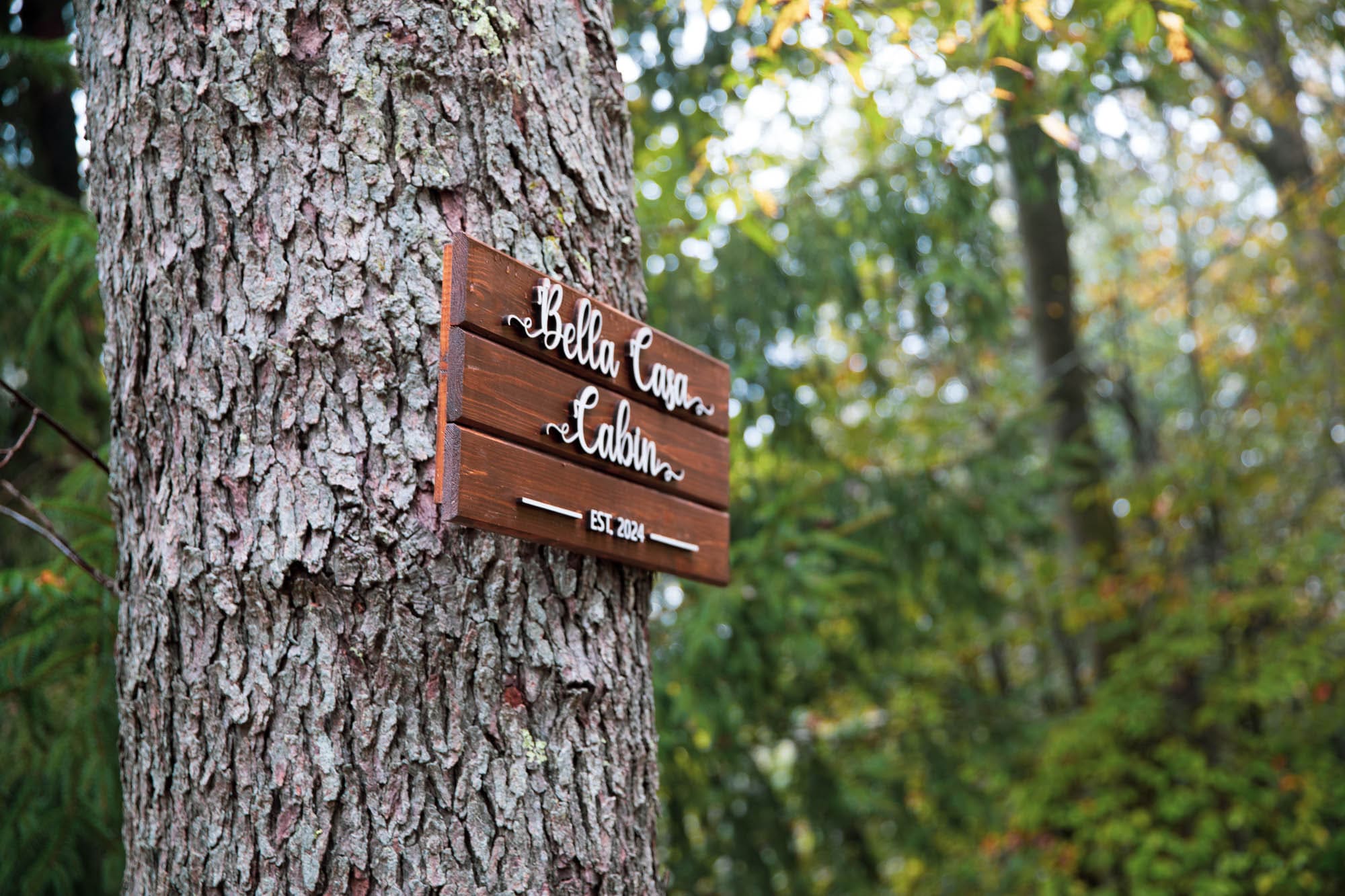 Cabin sign mounted on a tree at the entrance of the Pocono A-Frame retreat